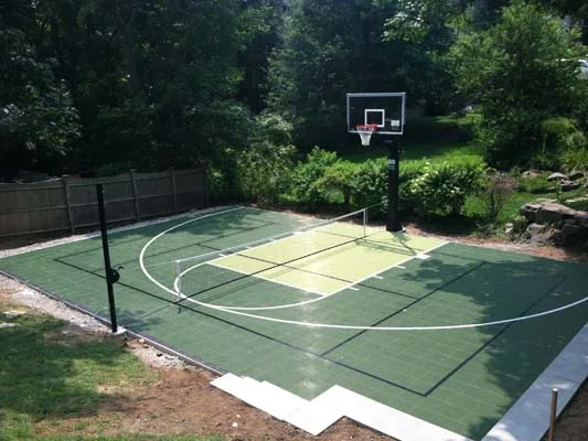 Custom green backyard multi-sport court with basketball hoop and pickleball net built by Boise Court Pros